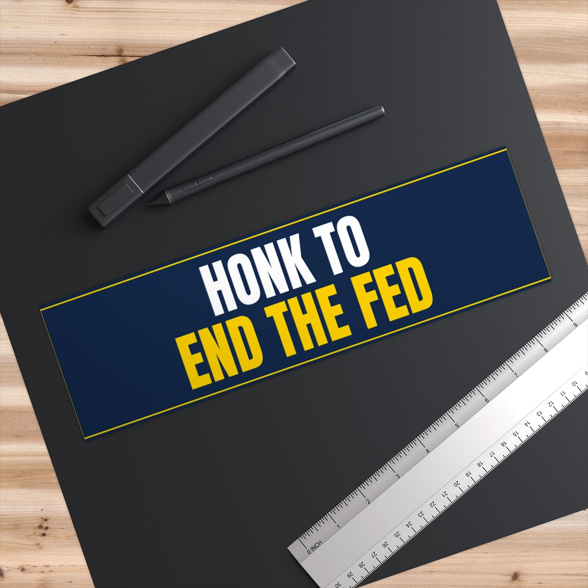 Honk to End the Fed Bumper Sticker - on a desk next to a ruler, shown at true 11" x 3" scale