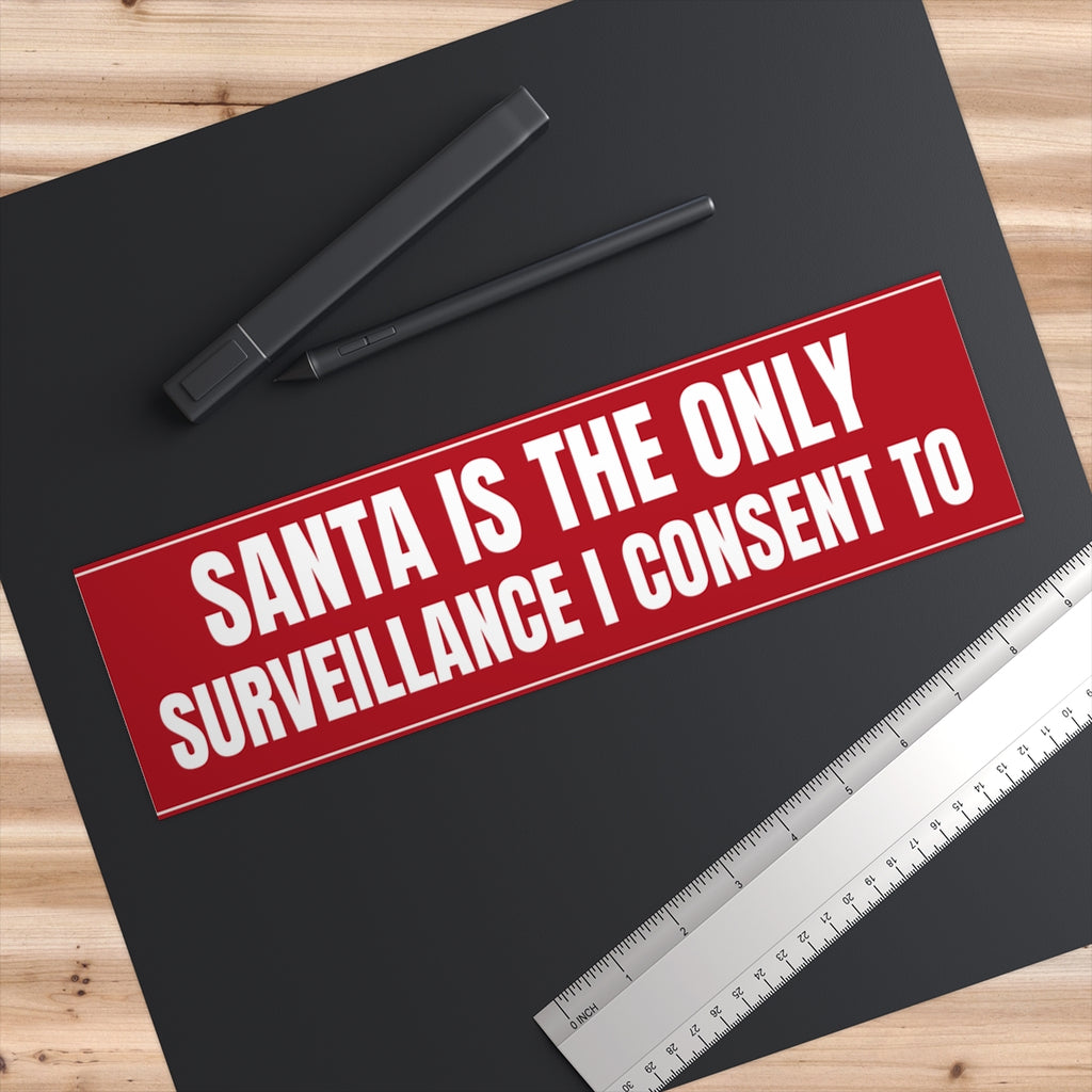Santa Is the Only Surveillance I Consent To Bumper Sticker - on a desk next to a ruler, shown at true 11" x 3" scale